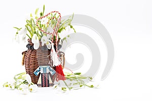 Bouquet of snow drops in a basket tied with red and white string on white background and decoration first of march celebration mar