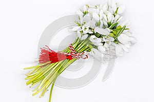 Bouquet of snow drops tied with red and white string on white background  first of march celebration martisor