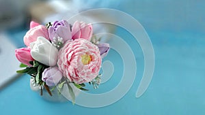 Bouquet of soap flowers on blurred blue background.