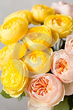 Bouquet of soft pink and yellow garden roses in a glass vase. Floral still life. close-up