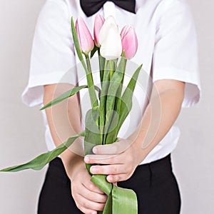 Bouquet of spring flowers in children`s hands.