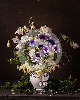 Bouquet of spring flowers in a porcelain vase on a dark background