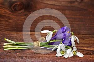 The bouquet of spring flowers snowdrops and crocuses on wood