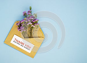 A bouquet of spring wildflowers in an envelope and the inscription thank you to the doctor and nurses