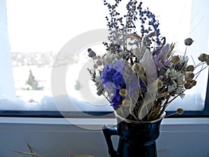 A bouquet of summer flowers on a background of a snowy landscape outsid photo