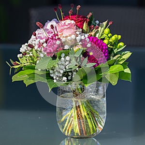 Bouquet summer flowers in bright colors, pink roses, cloves, purple dahlia, green leaves