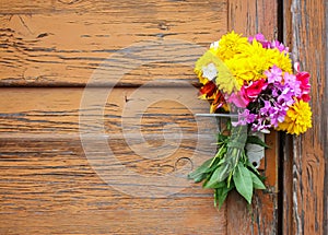 Bouquet of summer flowers on rough weathered wooden door background.