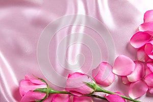 a bouquet sweet pink roses petal on soft pink silk fabric , romance and love card concept