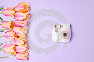 Bouquet of tulips and brown camera on purple baackground photo