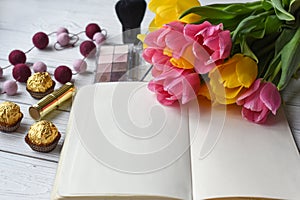 A bouquet of tulips, a note book, some jewellery, eye shadows, sweets, palette