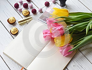 A bouquet of tulips, a note book, some jewellery, eye shadows, sweets, palette