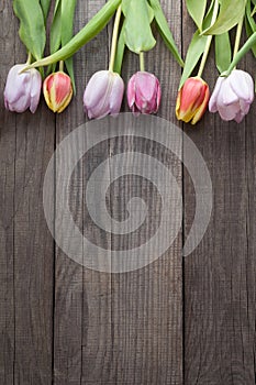 bouquet of tulips of spring flowers on old wooden board on holiday of Easter