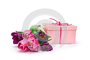 Bouquet of violet and pink tulips with pink gift box on a white background with space for text. Holiday spring composition