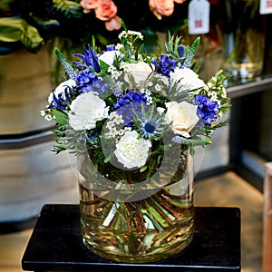 Bouquet with white and blue flowers in a glass vase