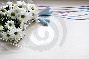 Bouquet of white chrysanthemums with tapes and two blue hearts on white background