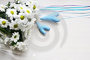 Bouquet of white chrysanthemums with tapes and two blue hearts on white background