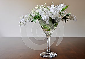 Bouquet of white flowers in martini glass.