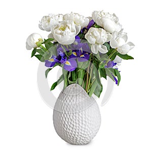 Bouquet of white peonies and irises in a white vase