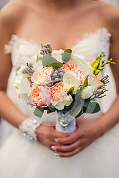 Bouquet of white and pink peonies in the hands of the bride