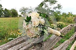 Bouquet of White and Pink Roses with Babys Breath on Split Rail Fence in Farm Field