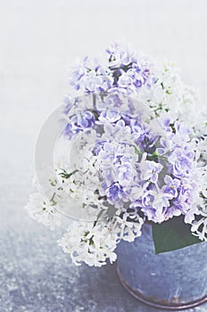 Bouquet of white and purple lilac flowers in metal bowl