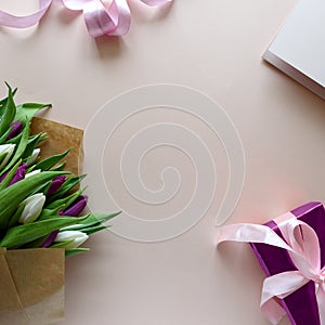 Bouquet of white and purple tulips, gift box and blank paper on pink background. Top view. Flat lay. Copy space. Valentines day,