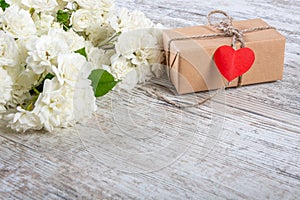 A bouquet of white roses, a box with a gift and a heart for inscription.