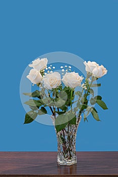 Bouquet of white roses with green leaves and small white flowers