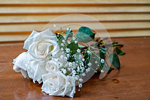 Bouquet of white roses with green leaves and small white flowers