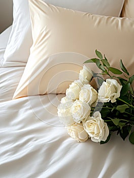 Bouquet of white roses on a white bed with pillows, creating an atmosphere of romance, comfort, and care. photo