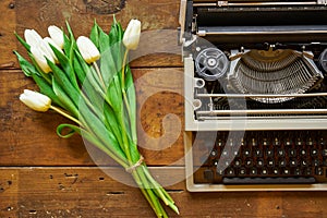 Bouquet of white tulips and typewriter on wooden backgound top v