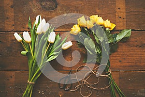 Bouquet of white tulips and yellow roses on wooden backgound to