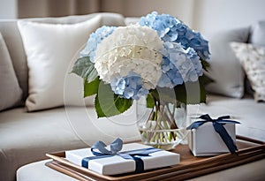 Bouquet of whitw and blue hydrangeas in vase on table in living room.