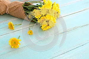 Bouquet of yellow chrysanthemum on blue wooden background.