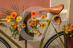 Bouquet of yellow and orange flowers on the bicycle