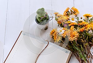 Bouquet of yellow and orange flowers on a white wooden table