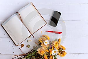 Bouquet of yellow and orange flowers on a white wooden table