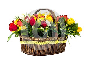 Bouquet of yellow and red tulips with wild flowers in a wicker b