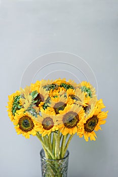 Bouquet of yellow sunflowers , flower in vase on old vintage table. Room morning. Gray background. Colors of autumn and