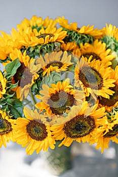 Bouquet of yellow sunflowers , flower in vase on old vintage table. Room morning. Gray background. Colors of autumn and