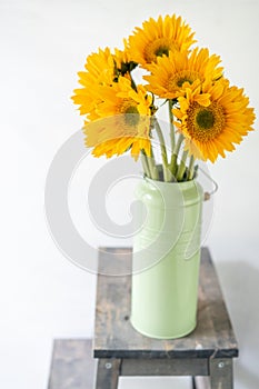 Bouquet of yellow sunflowers , flower in vase on old vintage table. Room morning. Gray background. Colors of autumn and