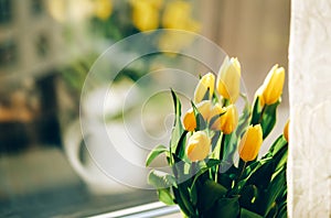 Bouquet of yellow tulip flowers on window sill