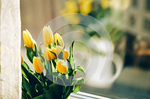 Bouquet of yellow tulip flowers on window sill