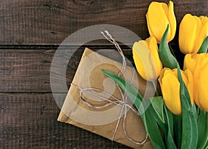 Bouquet of yellow tulips on dark rustic wooden background