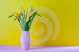 bouquet of yellow tulips in a vase on a yellow background