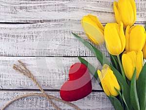 Bouquet of yellow tulips on white rustic wooden background