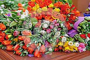 Bouquets of colorful tulips lie on a table for sale