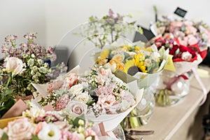 Bouquets on table, florist business. Different varieties fresh spring flowers. Delivery service. Flower shop concept.