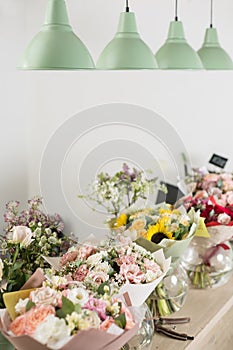 Bouquets on table, florist business. Different varieties fresh spring flowers. Delivery service. Flower shop concept.