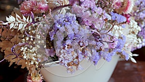 Bouquets with white, purple and violet dried flowers and leaves for sale in flower shop.